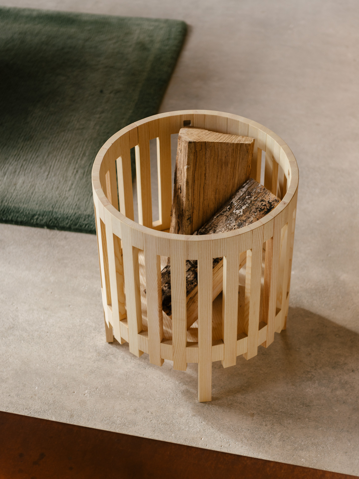 Ein wertiger Holzkorb für Brennholz im Wohnzimmer am Kamin aus Esche Vollholz, geölt.